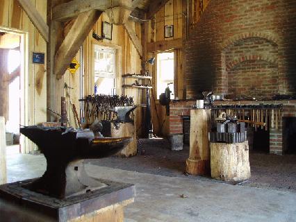 The inside of the blacksmith shop with an anvil in the foreground.